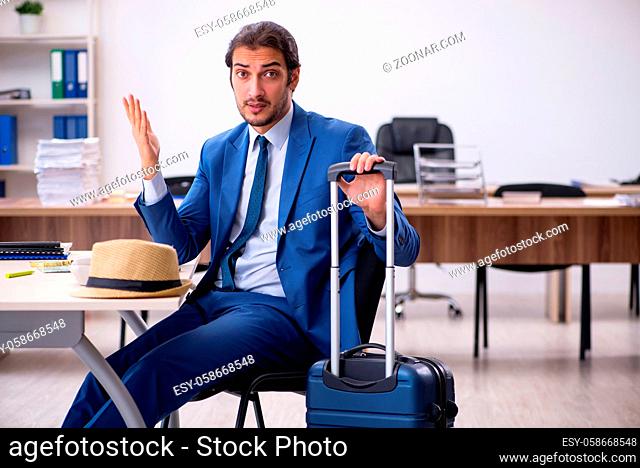 Young businessman employee preparing for trip in the office