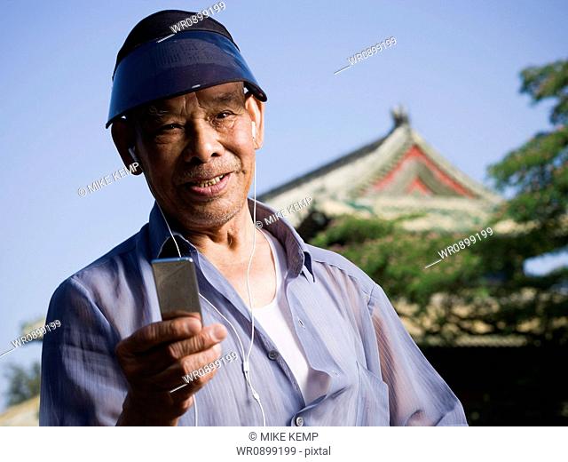 Mature man with mp3 player and earbuds smiling