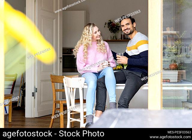 Happy couple sitting together on table