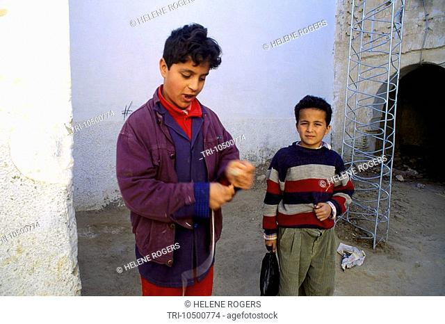 Nefta Tunisia Young Teenage Boy & Younger Boy Playing with Spinning Tops