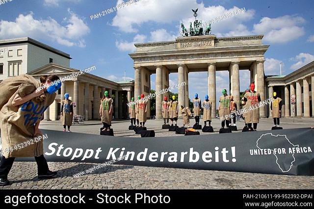 11 June 2021, Berlin: Members of the alliance ""Together for Africa"" take part in a performance in front of the Brandenburg Gate to protest against child...