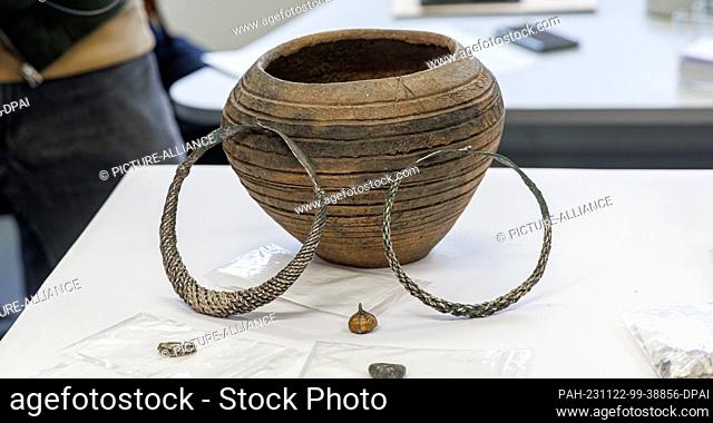 22 November 2023, Mecklenburg-Western Pomerania, Schwerin: A clay jar containing two silver necklaces, jewelry and coins is one of the latest archaeological...