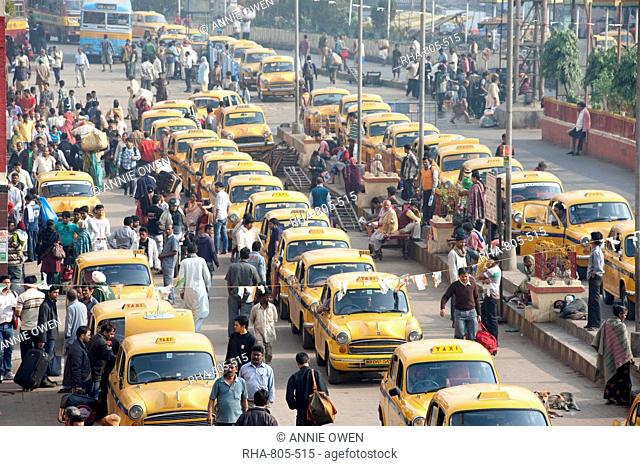 Yellow Kolkata taxis and commuters outside Howrah Railway Station in morning rush hour, Howrah, Kolkata Calcutta, West Bengal, India, Asia