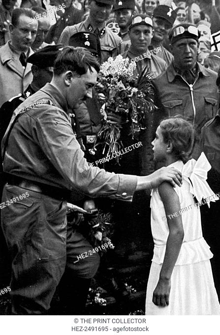 Adolf Hitler talking with a young girl during his election campaign, 1932. Hitler (1889-1945) finished second to Paul von Hindenburg in the 1932 German...