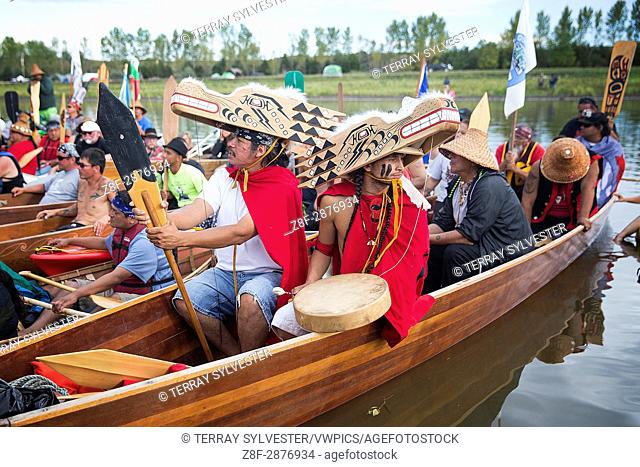Marco Black (left) and Micah Masten of the Quinault Indian Nation in Washington State wear wolf masks while moored on the banks of the Cannonball River near the...