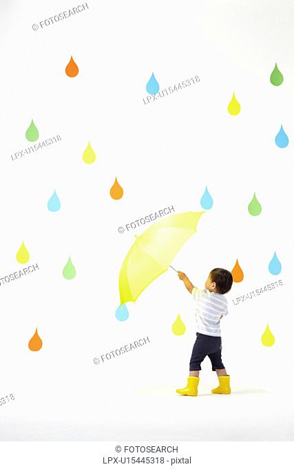 Boy Under Umbrella in Colourful Rain