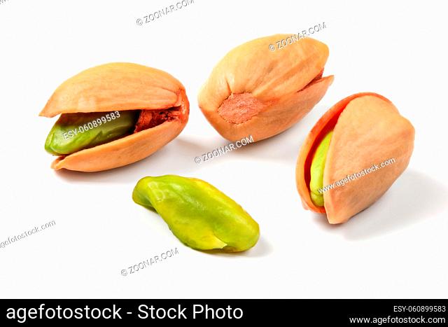 Turkish red roasted pistachios in shell, some of green nuts visible, isolated on white background