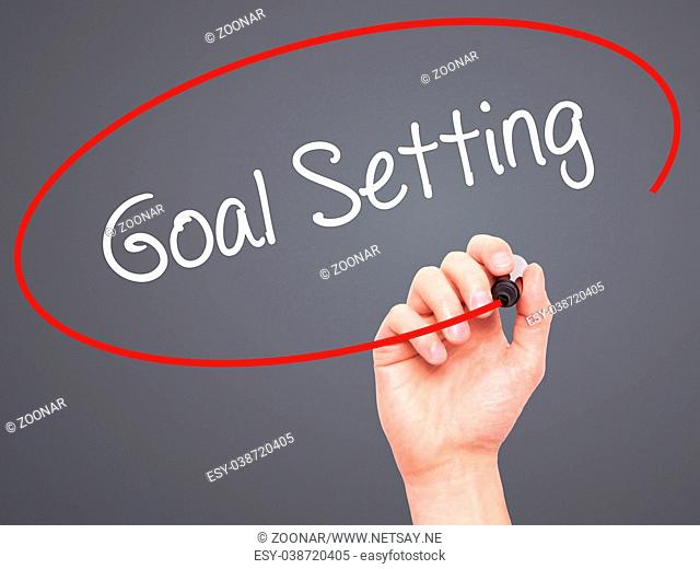 Man Hand writing Goal Setting with black marker on visual screen