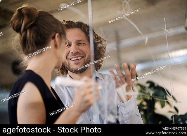 Smiling businessman and businesswoman working on a project in office