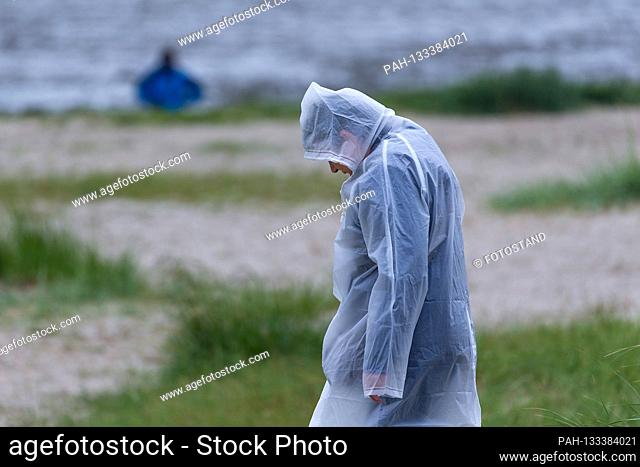 Harlesiel / Carolinensiel, Germany June 2020: Symbolic pictures - 2020 woman stands with raincoat, rain protection cover