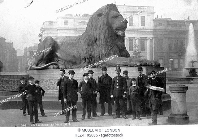 Policeman and men in front of the lion, Trafalgar Square, Westminster, London, late 19th-early 20th century. The lions at the base of Nelson's Column were...