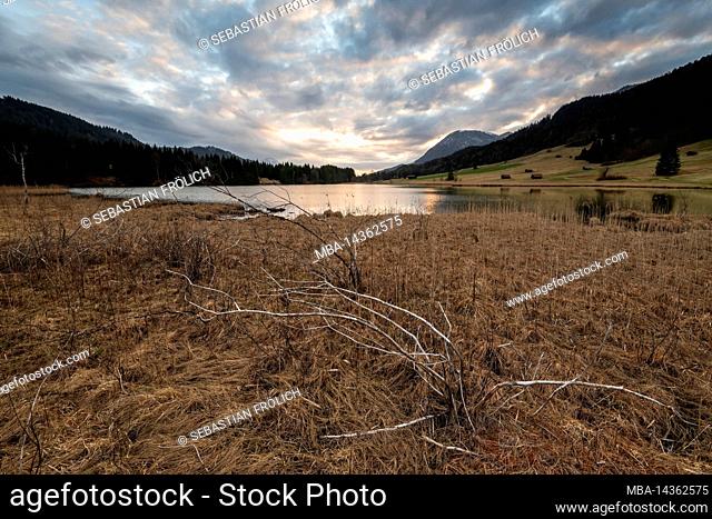 Cloudy atmosphere with sunset colors at autumnal Geroldsee, also Wagenbrüchsee in the Bavarian Alps near Garmisch -Partenkirchen