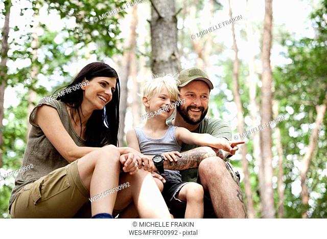 Happy family with son sitting in forest