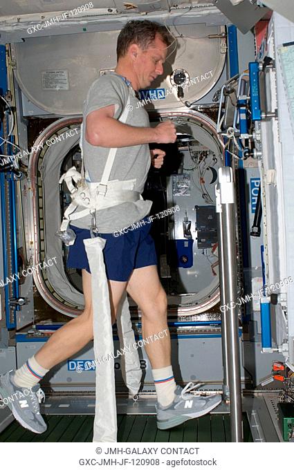 NASA astronaut T.J. Creamer, Expedition 22 flight engineer, equipped with a bungee harness, exercises on the Combined Operational Load Bearing External...