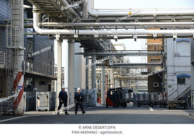 Chemical workers walk across the plant of the pharmaceutical and chemical company Merck KGaA in Darmstadt,  Germany, 06 March 2014