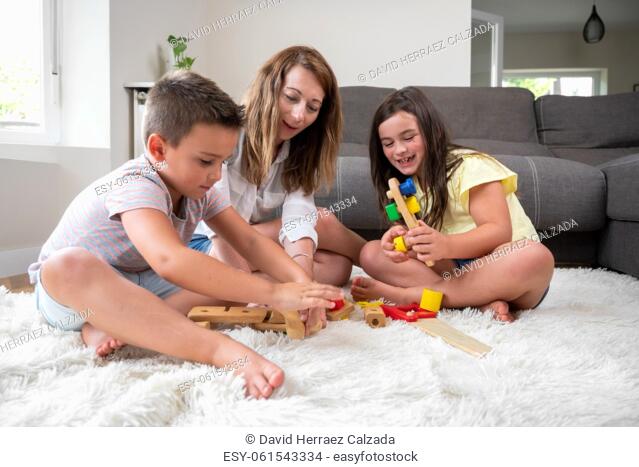 Single mother playing with her kids at home. High quality photography