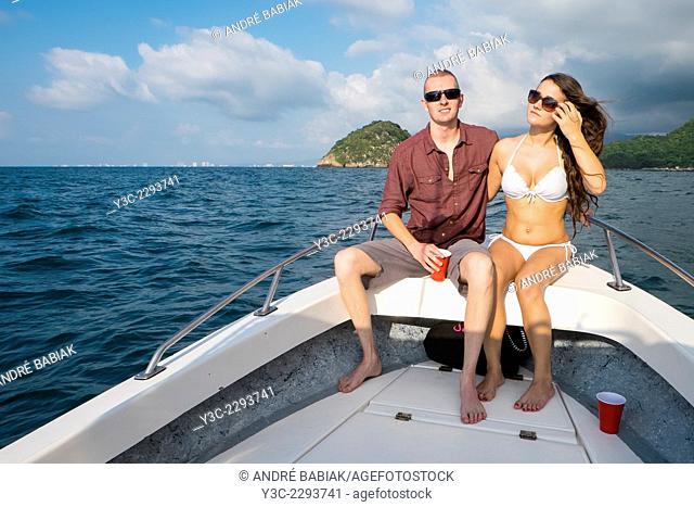Young woman and man in swimsuits enjoying a private boat tour to Los Arcos National Marine Park, Pacific ocean, Banderas Bay, Mexico