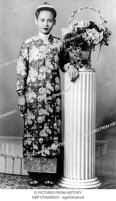 Thailand: A Phuket woman of Chinese ethnic origin poses in a Penang Nonya dress in this 1950 studio photograph