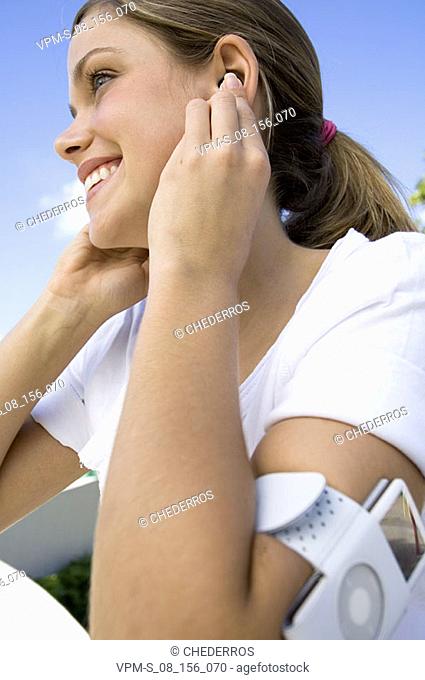 Side profile of a young woman listening to an MP3 player