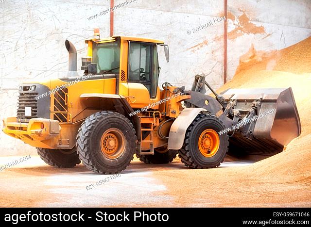 Wheel loader, excavator loading sand at construction site