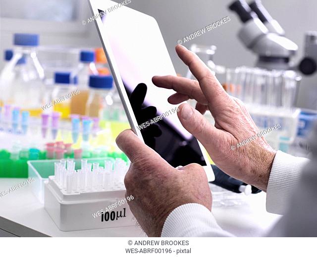 Scientist adding data online via a tablet from a experiment