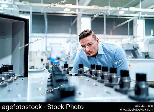 Male professional examining machine in industry
