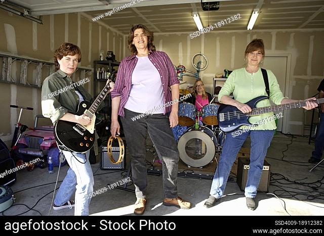 Portrait of Garage band composed of middle aged women, practicing in residential garage