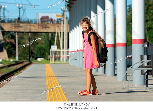 The eight-year-old girl on the platform of the train station looked funny in the frame
