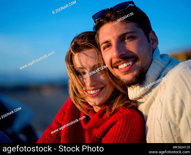portrait of young couple having fun on beach during autumn sunny day