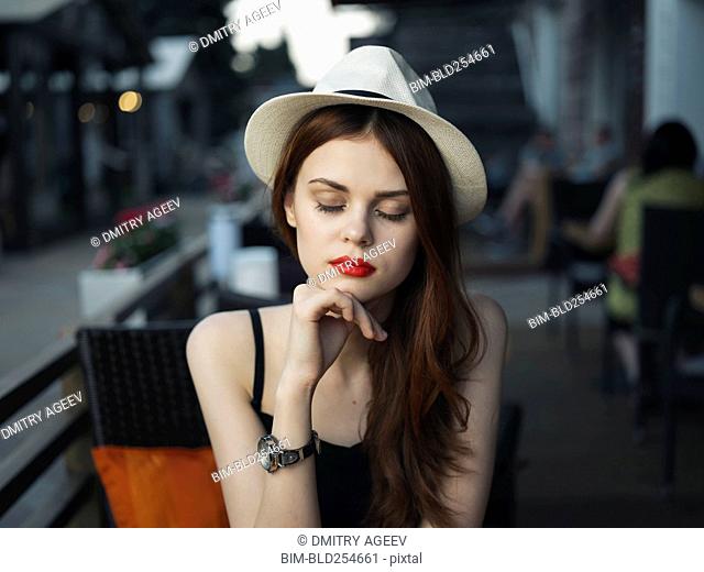 Pensive Caucasian woman at sidewalk cafe