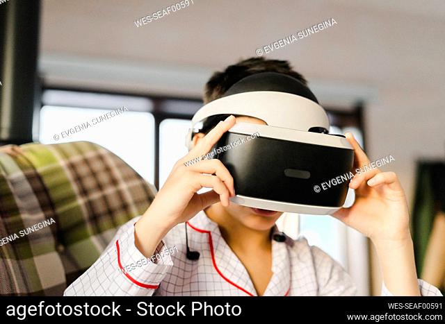 Boy wearing virtual reality simulator at home