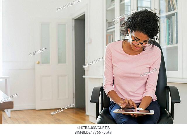 Mixed Race woman using digital tablet