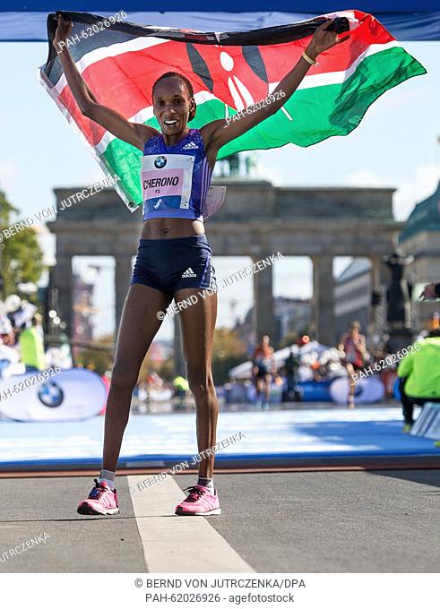 Gladys Cherono of Kenya holds the Kenyan flag in her hands and celebrates after crossing the finishing line as the first female runner during the 42th edition...