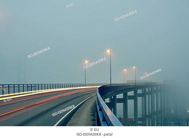 Diminishing perspective of light trails on misty elevated road illuminated by street lights, Haugesund, Rogaland County, Norway
