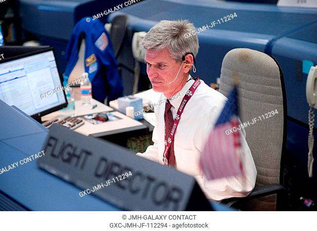 Flight director Bryan Lunney monitors data at his console in the space shuttle flight control room in the Mission Control Center at NASA's Johnson Space Center...