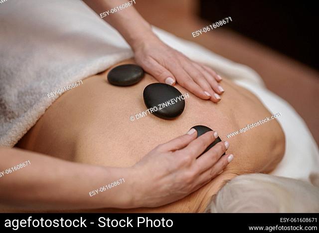 Stone massage . Close up picture of a woman having stone back massage