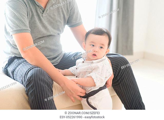 Happy Asian family at home. Father babysitting son, living lifestyle indoors