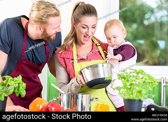 Mom, dad and child in kitchen tasting food