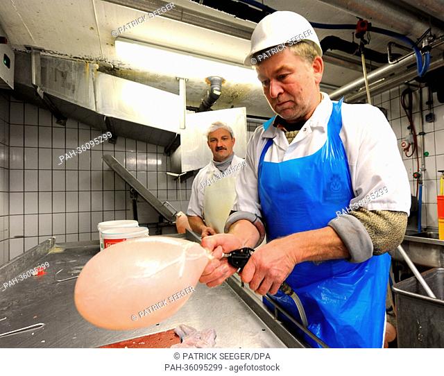 Butcher Hermann Disch from butcher's shop Winterhalter fills up pig bladders with air in Elzach, Germany, 9 January 2013