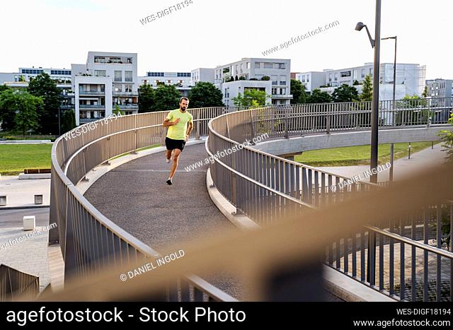 Young man running on elevated walkway
