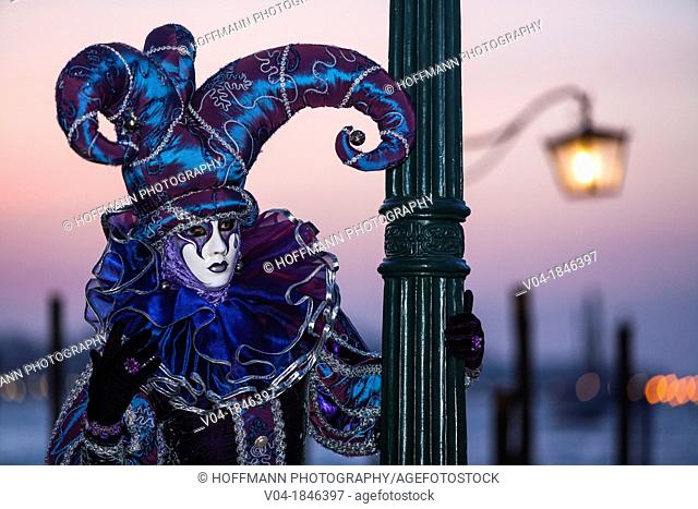 A masked harlequin at the carnival in Venice, Italy, Europe
