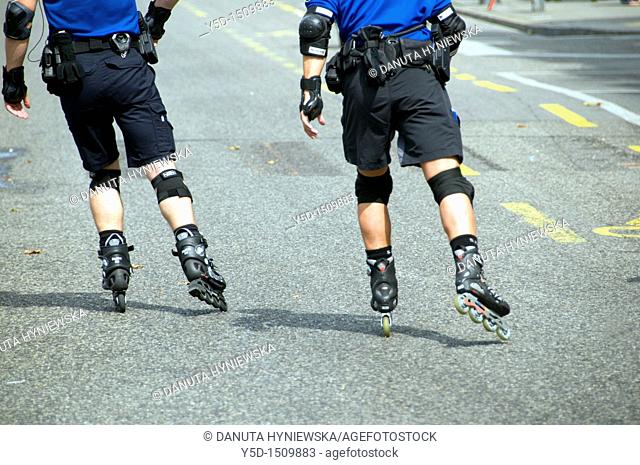 two policements on duty roller-skating forward on the street, Geneva, Switzerland