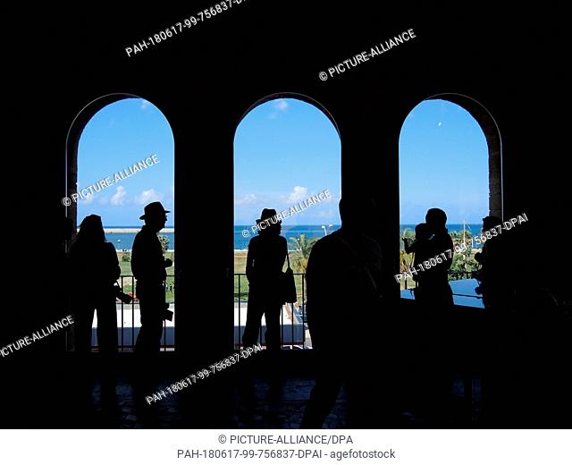 16 June 2018,  Italy, Palermo: Visitors of the Manifesta 12 stand in front of windows of the Palazzo Forcella De Seta in Palermo