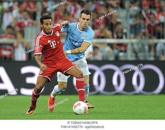 Munich's Thiago Alcantara and Alvaro Negredo (R) of Manchester vie for the ball during the Audi Cup soccer final match FC Bayern Munich vs Manchester City FC at...