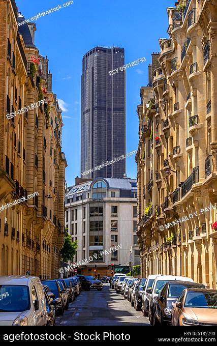 France. Paris. Montparnasse Tower at the end of a narrow street. Sunny summer day. Lots of parked cars