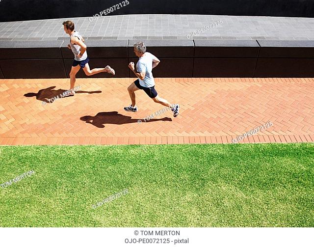 Men running on brick sidewalk