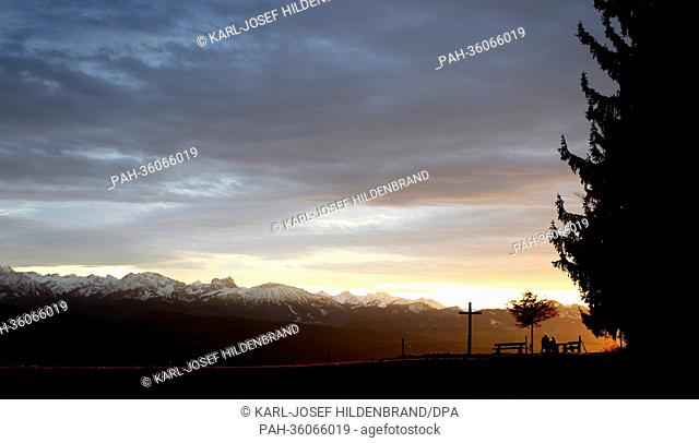 People enjoy the panoramic view of the Alps during sunset on the Auerberg mountain near Bernbeuren, Germany, 08 January 2013