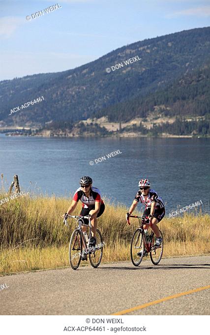 Teenage female Road cyclists over looking Kalamalka Lake, near Vernon, Okanagan, British Columbia, Canada