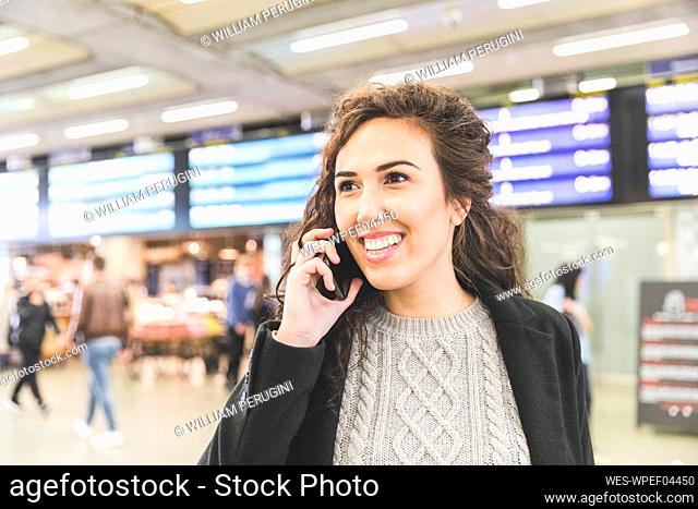 Happy businesswoman looking away while talking on mobile phone