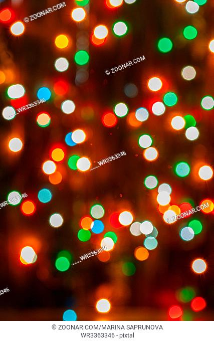 Red, yellow, green and blue blurry lights Christmas lights on dark background